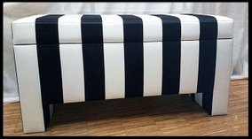 En kista med lock och förvaring tillverkad i samarbete med en inredningsarkitekt i svart och vitt bredrandigt tyg.
